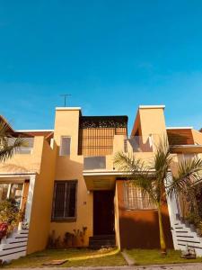 a house with a palm tree in front of it at Wind and Wave Villa No 2, 2BHK Near Pondy Auroville Pondicherry in Marakkānam +45 photos