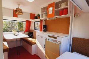 a small kitchen with a stove and a sink at small retro caravan in Leek