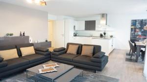 - un salon avec un canapé et une table dans l'établissement Ferienwohnung XL Komfort 8B, à Daisendorf