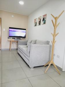 Una sala de estar con un sofá y un televisor de pantalla plana. en Departamento Altos de Ushuaia, en Ushuaia