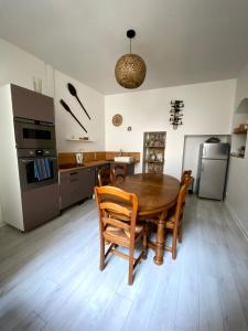 een keuken en eetkamer met een houten tafel en stoelen bij Gîte Les Domaines in Avallon