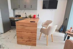 a kitchen with a wooden counter and a chair at 1 apartament lux cu parcare privată gratuită in Iaşi