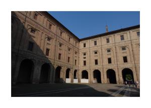a large stone building with arches and a blue sky at Historic center Teatro Regio appartamento Luca in Parma