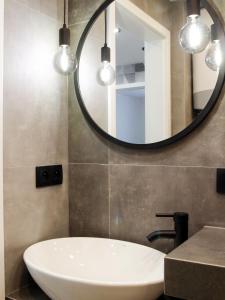 Apartament Comfy في نوفي سوكز: حمام مع حوض أبيض ومرآة