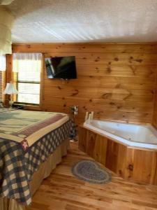 a bedroom with a bed and a tub in a room at Little Cabin All To Yourself in Sevierville