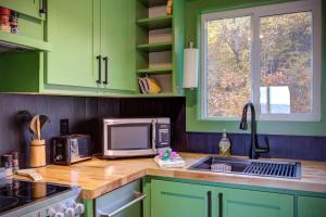 a kitchen with green cabinets and a sink and a microwave at Pour Some Sugar On Me - Long-Range Mountain Views in Sugar Mountain