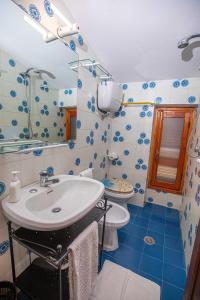 uma casa de banho azul e branca com um lavatório e um WC em Affitti Brevi Toscana - Nel verde vicino al Mare em Fonteblanda