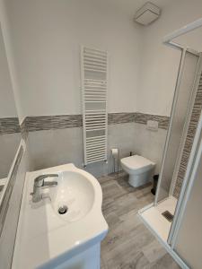 Baño blanco con lavabo y aseo en Domus Anna, en Montegrotto Terme