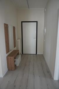 an empty room with a door and a wooden floor at Domus Anna in Montegrotto Terme