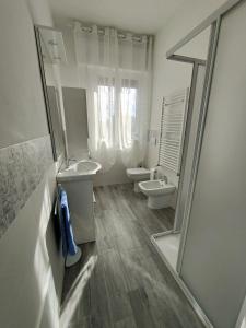 a white bathroom with two sinks and a mirror at Domus Anna in Montegrotto Terme