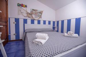 um quarto com uma cama com riscas azuis e brancas em Affitti Brevi Toscana - Nel verde vicino al Mare em Fonteblanda
