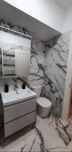 a stone bathroom with a sink and a toilet at 1 apartament lux cu parcare privată gratuită in Iaşi