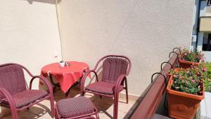 a patio with a table and chairs and plants at Gregovic Apartments in Petrovac na Moru