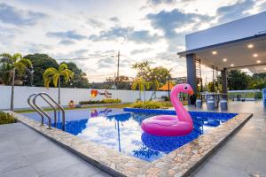 a pool with a pink flamingo in the water at Good2Stay Villa in Melaka