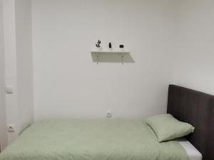 1 dormitorio con cama verde y estante en la pared en Apartment Mademoiselle, en Višegrad