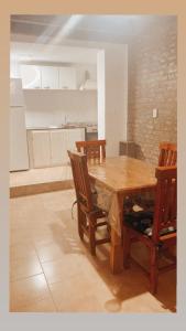 eine Küche mit einem Holztisch und Stühlen in der Unterkunft SAN MARINO in Villa María