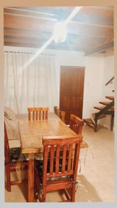 ein Esszimmer mit einem Holztisch und Stühlen in der Unterkunft SAN MARINO in Villa María