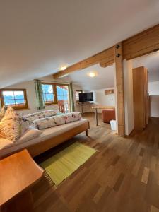 a bedroom with a large bed and a living room at Haus Alpenglühn in Schladming
