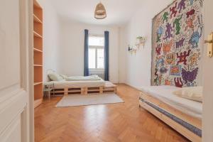 a room with two beds and a wall with a mural at hostel mapijaru in Klagenfurt