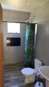 baño con aseo y lavabo y ventana en Toca do Siri, en Imbituba