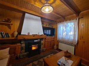 uma sala de estar com lareira e televisão em Casa Rural Castellanos em Huelamos