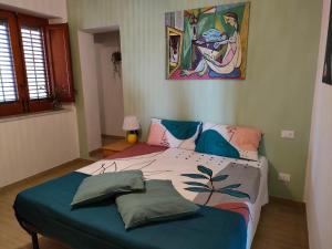 een slaapkamer met een bed met een schilderij aan de muur bij mdresort villa fronte mare in Trabia