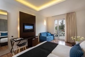 una camera d'albergo con un letto, una scrivania e una sedia di Hotel Yehuda a Gerusalemme