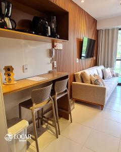 a living room with a couch and a table and chairs at Flat luxo no Mana Beach em Muro Alto 4 pessoas in Porto De Galinhas