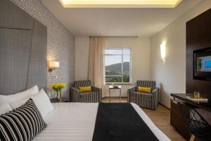 耶路撒冷的住宿－耶胡達酒店，酒店客房设有一张床、两把椅子和一扇窗户。