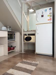a kitchen with a white refrigerator in a room at Premium Loft of the Fountain Small Plaza w/Netflix in Buenos Aires