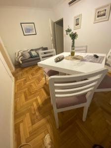 una mesa blanca y sillas en una sala de estar con suelo de madera. en EN EL CORAZON DE PALERMO -CABA-Buenos Aires en Buenos Aires