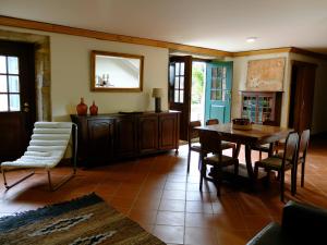 a dining room with a table and chairs and a mirror at Casas da Azenha do Rio in Barreiros