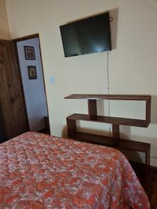a bedroom with a bed and a flat screen tv at Cabaña Alma 2 in Villa Carlos Paz
