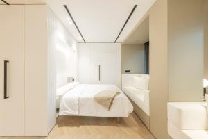 a bedroom with white walls and a bed and a sink at MyHouseSpain - Luminoso piso en Chamberí in Madrid