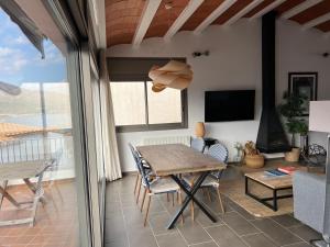 a dining room with a table and chairs and a tv at Big family house in the Center of el port de la selva in Port de la Selva