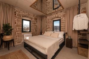 1 dormitorio con cama y pared de ladrillo en She House - built for pleasure - Island of Brač, en Gornji Humac