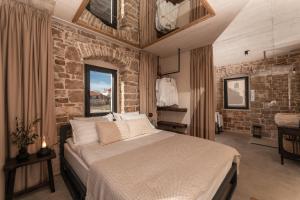 1 dormitorio con 1 cama grande y pared de piedra en She House - built for pleasure - Island of Brač, en Gornji Humac
