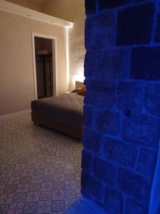 een kamer met een blauwe bakstenen muur en een bed bij Domus Duomo B&B Napoli in Napels