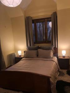 a bedroom with a bed with two lamps and a window at Welcome to Chalet B. in Ifrane