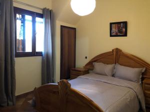 a bedroom with a wooden bed and a window at Welcome to Chalet B. in Ifrane