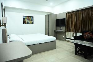 a hotel room with a bed and a desk at ELGIN SUITES in Kolkata