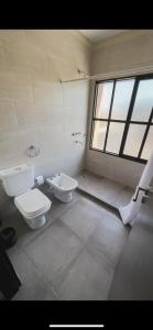 y baño con aseo y lavamanos. en Departamentos Rosina 1 en San Fernando del Valle de Catamarca
