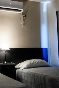 a bedroom with a bed with a blue stripe on the wall at Departamentos Rosina 1 in San Fernando del Valle de Catamarca