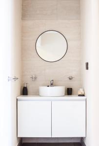 ein Badezimmer mit einem weißen Waschbecken und einem Spiegel in der Unterkunft Departamentos Rosina 1 in San Fernando del Valle de Catamarca