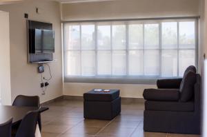 a living room with a couch and a tv at Departamentos Rosina 1 in San Fernando del Valle de Catamarca