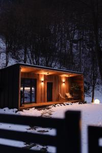 a small wooden house in the snow with lights at KONTAINERLOFT in Laz