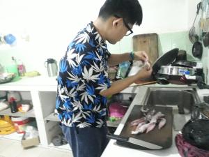 Een man in een keuken die eten klaarmaakt. bij Jungle city Hostel in Galle