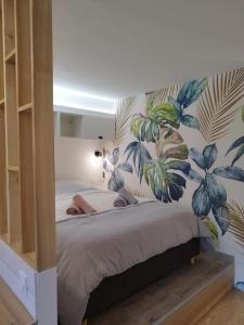 Un dormitorio con una cama grande con papel pintado tropical. en Home Sweet Metz & Place de parking privée, en Metz
