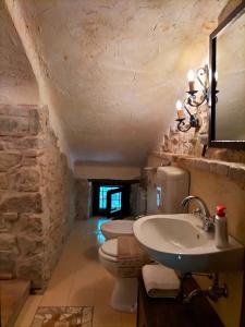 ein Bad mit 2 Waschbecken und einem WC in einem Steingebäude in der Unterkunft Old House in Penna San Giovanni