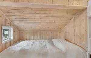 Cama en habitación de madera con ventana en 3 Bedroom Lovely Home In Fllenslev, en Føllenslev